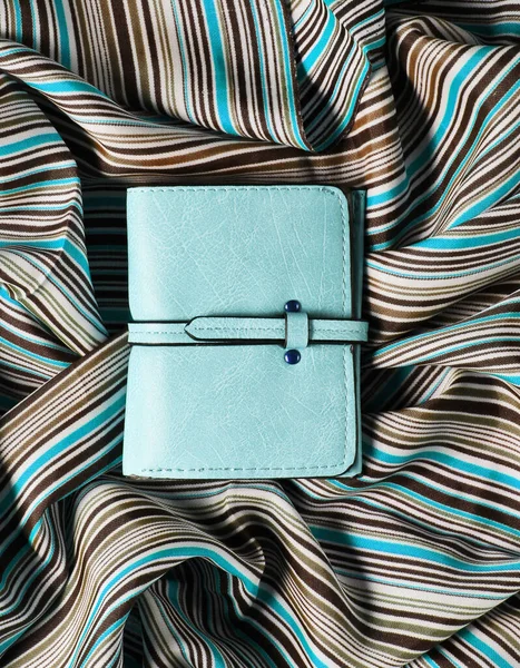 Kumaş arka planda mavi deri cüzdan. Üst görünüm