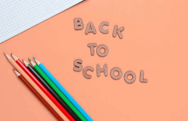 学校时间概念 五颜六色的铅笔 带有蓝色背景的笔记本 带着木制字母回到学校 — 图库照片