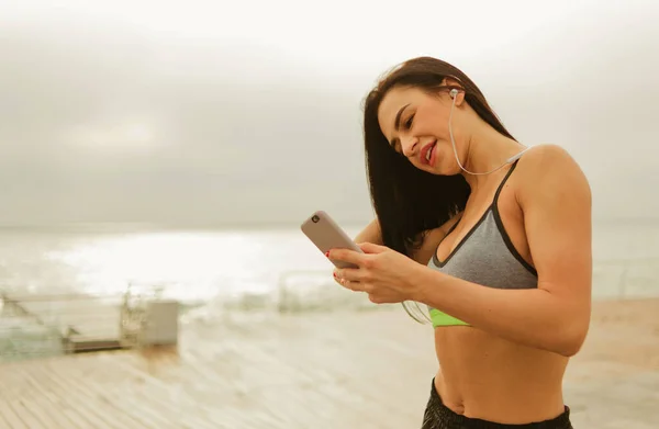 Jong Fit Brunette Vrouw Luisteren Muziek Met Hoofdtelefoon Holding Smartphone — Stockfoto