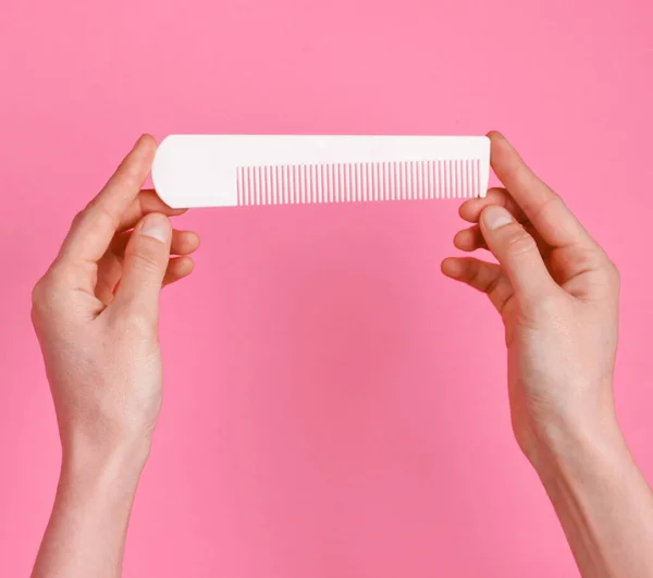 Female Hands Holding White Plastic Comb Pink Background Hair Care — 图库照片
