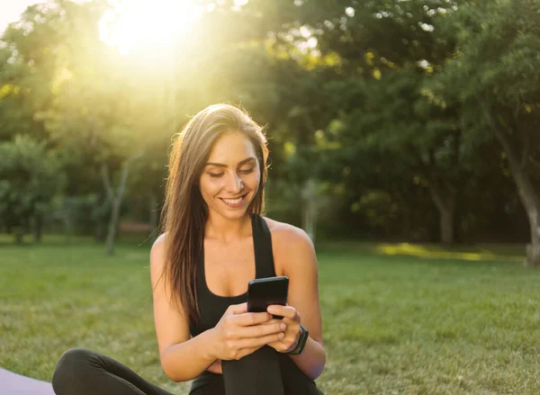 Vrolijke Gezonde Fitness Vrouw Sportkleding Zittend Yoga Mat Chatten Smartphone — Stockfoto