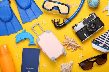 Kumsallı kompozisyon, sarı arka planda seyahat nesneleri. Üst Manzara. Düz yatıyordu. Deniz mesleği