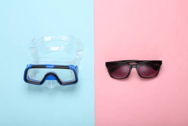 Yaz tatili. Mavi pastel arka planda dalış maskesi ve güneş gözlüğü. Minimum plaj tatili konsepti. Üst görünüm