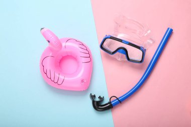 Yaz tatili. Dalış takımı ve mavi pastel arka planda şişme flamingo. Minimum plaj tatili konsepti. Üst görünüm