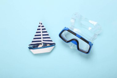 Mavi arka planda yelkenli dalış maskesi. Seyahat kavramı