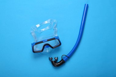 Mavi arka planda şnorkeli olan dalış maskesi. Denizde tatil, seyahat konsepti. Üst görünüm