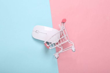 Pembe mavi arka planda bilgisayar faresi olan alışveriş arabası. İnternetten alışveriş