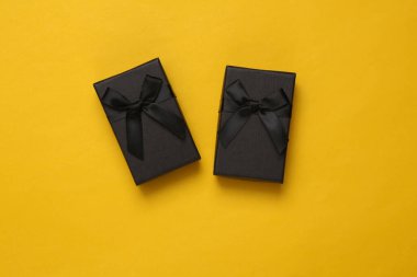 Sarı arka planda siyah hediye kutuları. Üst görünüm