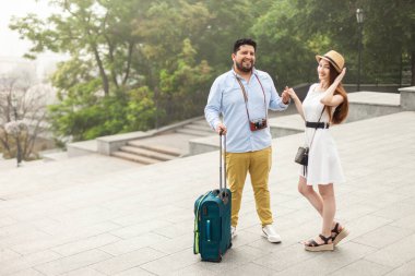 Şehirde bavulları olan genç uluslararası turistler