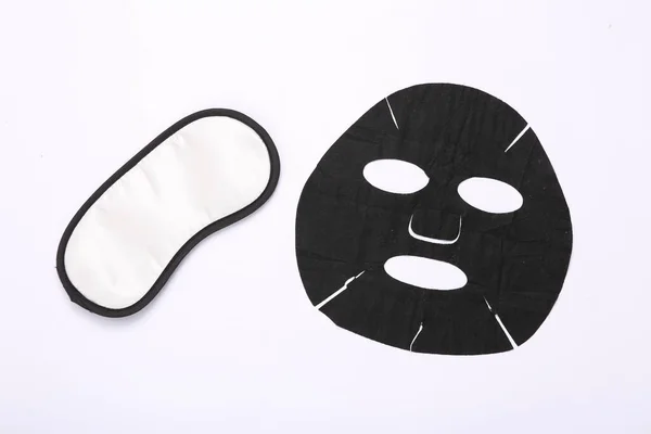 黒化粧クレンジングマスクと白い背景に眠るマスク — ストック写真