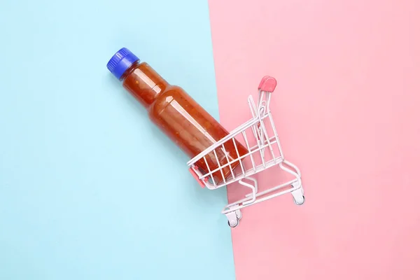 Carrinho Compras Com Garrafa Molho Tomate Ketchup Sobre Fundo Azul — Fotografia de Stock