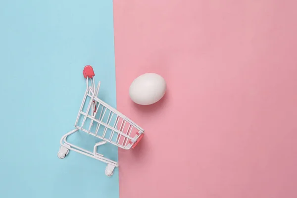 Carrinho Compras Com Ovo Fundo Pastel Rosa Azul — Fotografia de Stock