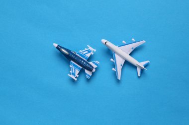 Mavi arka planda askeri avcı uçağı ve yolcu uçağı. Oyuncak Modelleri