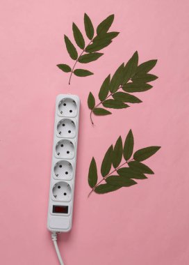 Elektrik uzatma kablosu ve mavi-pembe renkli arka planda yeşil yapraklar. Yeşil enerji. Üst Manzara. Düz yatıyordu