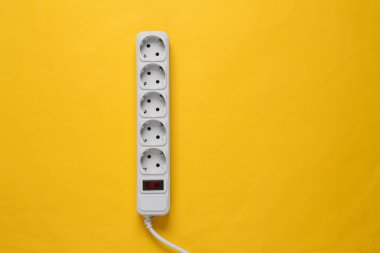 Sarı arka planda elektrik uzatma kablosu var. Üst Manzara. Düz yatıyordu