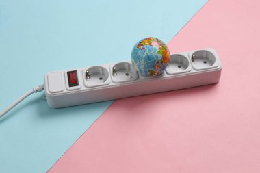 Gezegeni kurtar. Pembe mavi arka planda elektrik kablosu ve küre. Yeşil enerji.