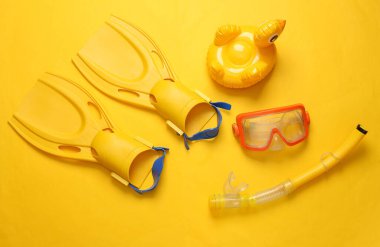 Dalış takımı ve sarı arka planda şişme ördek. Üst Manzara. Düz yatıyordu