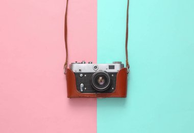Mavi-pembe pastel arka planda deri kapaklı Retro kamera
