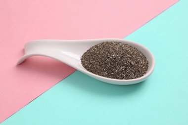 Mavi pembe arka planda chia ile seramik kaşık. Üst görünüm