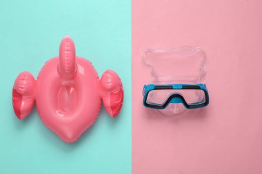 Pembe arka planda dalış maskesi olan şişme flamingo. Minimum yaz, plaj dinlenme konsepti.