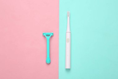 Tıraş makinesi ve mavi pastel arka planda diş fırçası. Üst görünüm