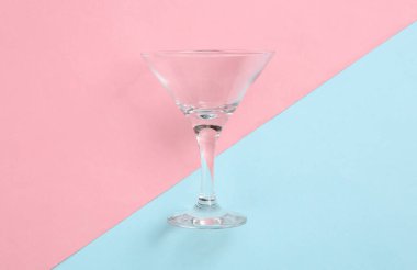 Mavi-pembe pastel arka planda boş bardakta kokteyl. Minimalizm. Üst görünüm