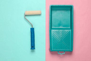 Pembe arka planda yuvarlanan boya için konteynırlı boya silindiri