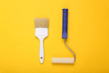 Sarı arka planda boya ve fırça. Ev yenileme konsepti. Üst görünüm 