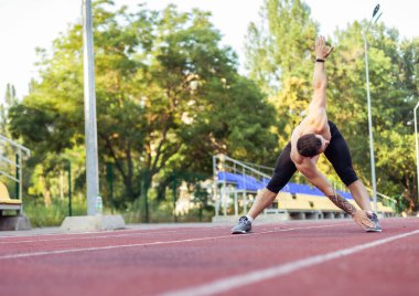 Stadyuma koşmadan önce çıplak gövdesiyle egzersiz yapan atletik bir adam. Sağlıklı yaşam tarzı