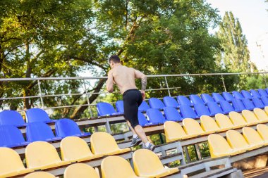 Yakışıklı atletik erkek stadyum tribününde koşuyor. Sağlıklı yaşam tarzı