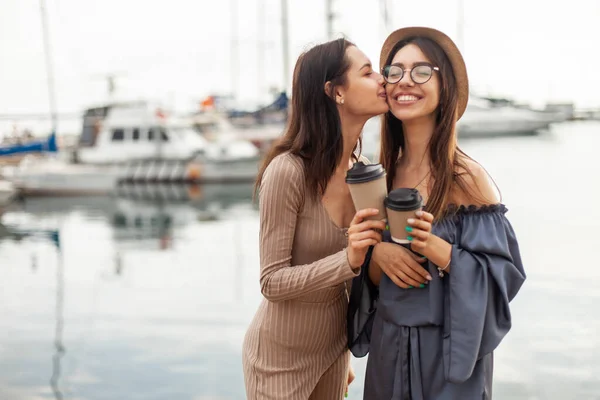 Duas Mulheres Divertidas Estão Beijando Bochecha Segurando Xícaras Café Clube — Fotografia de Stock
