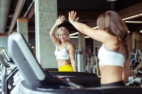 Duas Mulheres Atléticas Cumprimentam Enquanto Exercitam Uma Esteira Estilo Vida — Fotografia de Stock