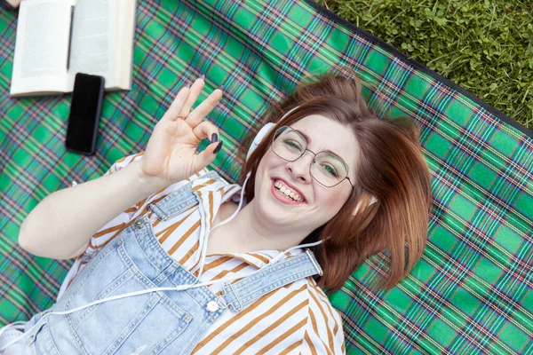 Молодая Веселая Женщина Слушает Музыку Наушниках Лежащих Одеяле Парке — стоковое фото