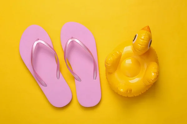 Aufblasbare Enten Und Flip Flops Auf Gelbem Hintergrund Minimales Sommerkonzept — Stockfoto