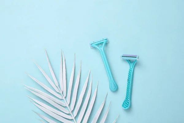 Disposable Razors Depilation Blue Background White Palm Leaves Top View — Stock Photo, Image