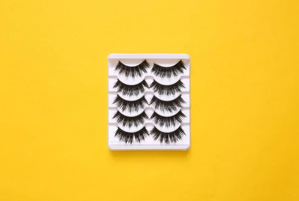 Set of false eyelashes on yellow background. Top view