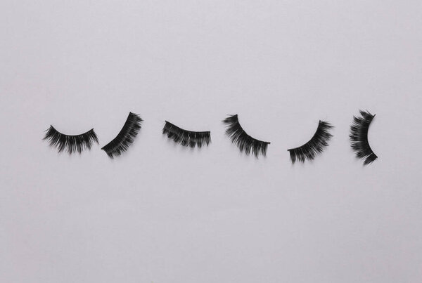 Ложные ресницы на сером фоне. Концепция красоты