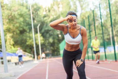 Stadyumda yorgun bir kadının portresi. Yoğun kardiyo çalışması, çalışma