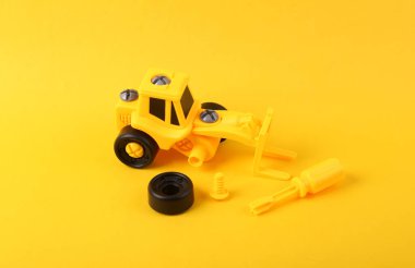 Sarı arka planda parçalanmış oyuncak yükleyici. Yenileme konsepti