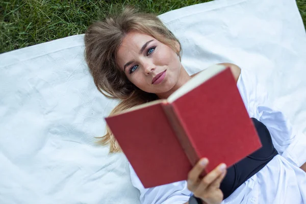 Roztomilé Atraktivní Žena Čtení Knihy Zatímco Leží Dece Trávě — Stock fotografie