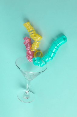 Mavi nane arkaplanlı yılanlı kokteyl bardağı. Minimum Noel partisi konsepti