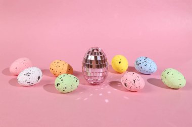 Pembe arka planda renkli Paskalya yumurtaları. Asgari Paskalya düzeni