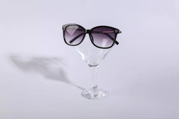 带有灰色背景太阳镜的鸡尾酒杯 最小党的概念 概念艺术 — 图库照片
