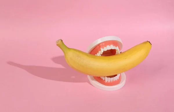 Пластиковая Челюсть Бананом Розовом Фоне — стоковое фото
