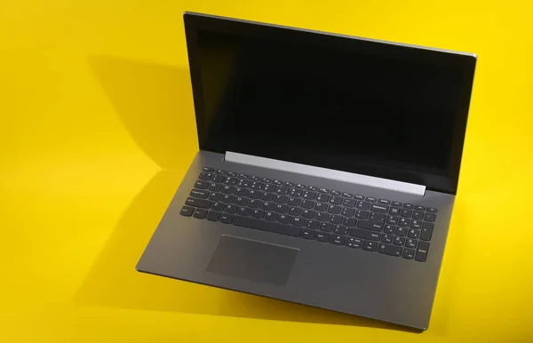 Mengangkat Laptop Modern Pada Latar Belakang Kuning — Stok Foto
