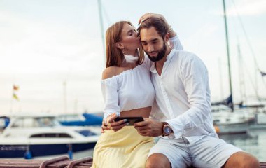 Aşık güzel bir çift birlikte vakit geçirir ve yat kulübünde akıllı telefondan video izlerler.