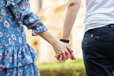 Genç ve sevgi dolu bir çiftin el ele tutuşması. Romantik konsept