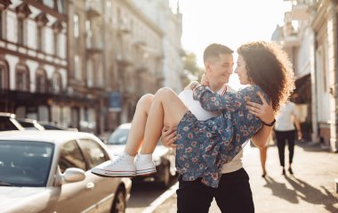 Young couple in love having fun in the city at sunset