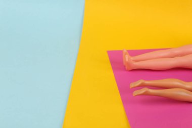 Plaj tatili kavramı. İki bebek bir paspasın üzerinde yatıyor ve sarı mavi arka planda güneşleniyor. En küçük yerleşim