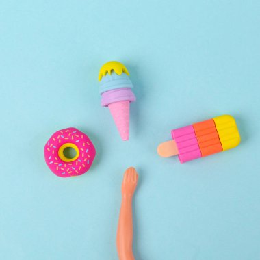 Oyuncak el dondurma, dondurulmuş meyve suyu ve mavi arka planda bir donut arasında seçim yapar. En küçük yerleşim